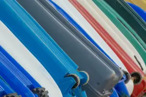 Draufsicht auf bunte Kajaks, die in Reihen im Freien gelagert sind.